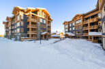 Experience luxury mountain living in this stunning ski resort property, featuring a modern architectural design with warm wood accents and dark blue siding.