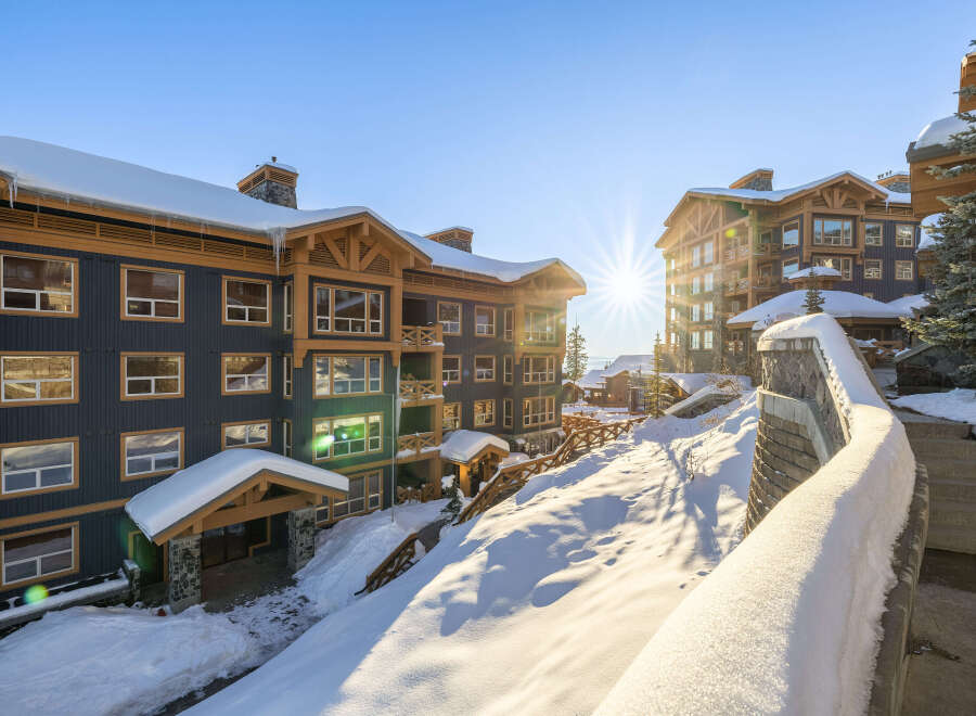 Experience luxury mountain living in this stunning ski resort property, bathed in the warm glow of a winter sun.