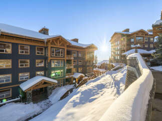 Experience luxury mountain living in this stunning ski resort property, bathed in the warm glow of a winter sun.