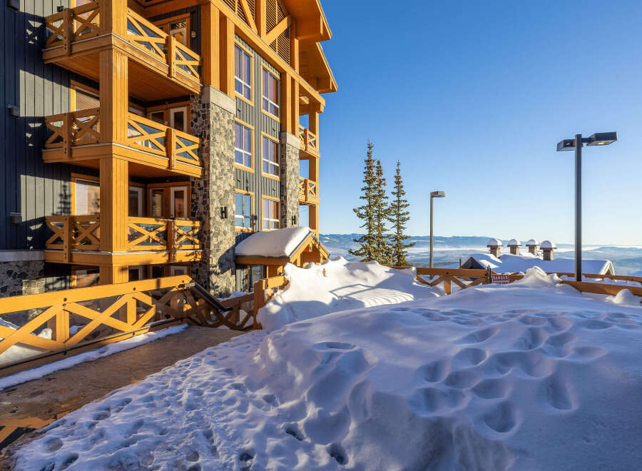 Experience luxury mountain living in this stunning property, featuring a modern timber-framed exterior and expansive balconies perfect for enjoying breathtaking panoramic views.