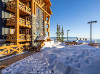 Experience luxury mountain living in this stunning property, featuring a modern timber-framed exterior and expansive balconies perfect for enjoying breathtaking panoramic views.