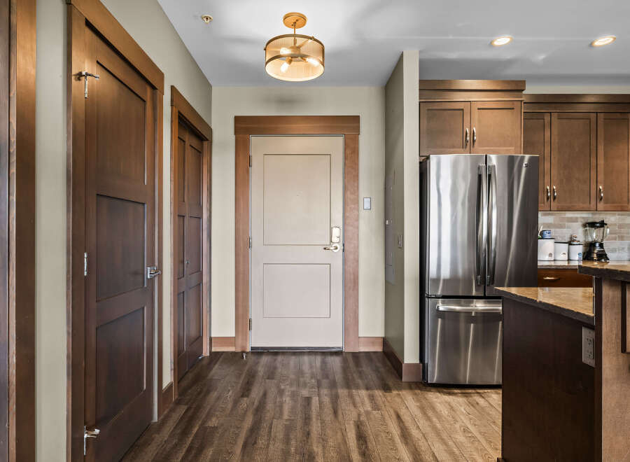 Step into this inviting entryway featuring rich wood doors and a stylish pendant light.