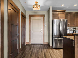 Step into this inviting entryway featuring rich wood doors and a stylish pendant light.