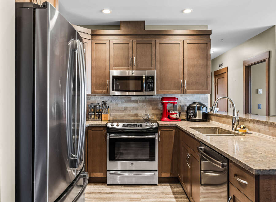 This modern kitchen features sleek stainless steel appliances, including a refrigerator, microwave, and oven.
