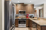 This modern kitchen features sleek stainless steel appliances, including a refrigerator, microwave, and oven.