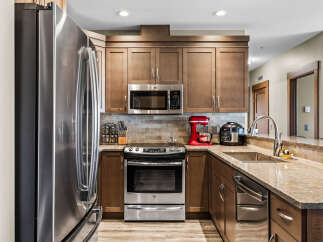 This modern kitchen features sleek stainless steel appliances, including a refrigerator, microwave, and oven.