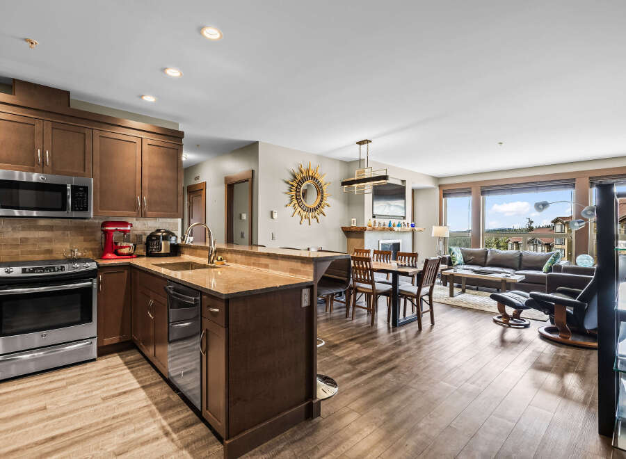 Experience modern living in this open-concept space featuring a gourmet kitchen with stainless steel appliances and rich wood cabinetry.