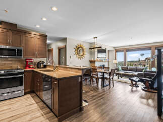 Experience modern living in this open-concept space featuring a gourmet kitchen with stainless steel appliances and rich wood cabinetry.