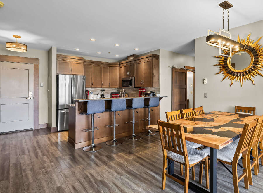 Experience modern living in this stunning condo featuring a gourmet kitchen with stainless steel appliances and a breakfast bar, perfect for casual dining.