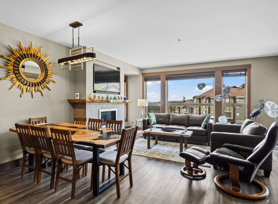 Experience luxury living in this stunning dining and living area, featuring a unique live-edge dining table and a cozy fireplace.