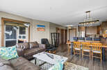 Experience modern living in this spacious open-concept condo, featuring a comfortable leather sectional sofa and a stylish dining area perfect for entertaining.