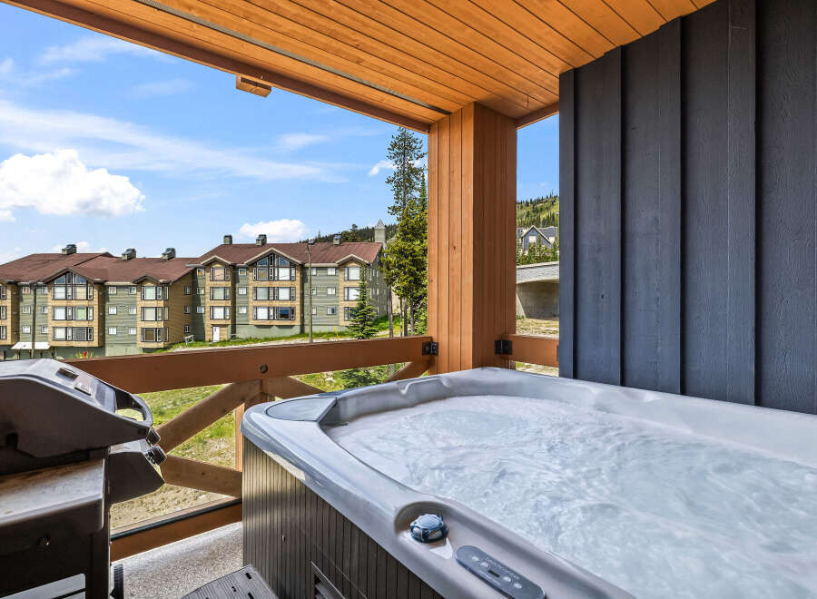 Enjoy ultimate relaxation on this private balcony, complete with a bubbling hot tub and a grill, perfect for outdoor entertaining.