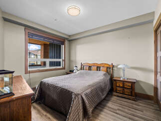 This charming bedroom features a comfortable queen-size bed with a quilted comforter, perfect for a restful night's sleep.