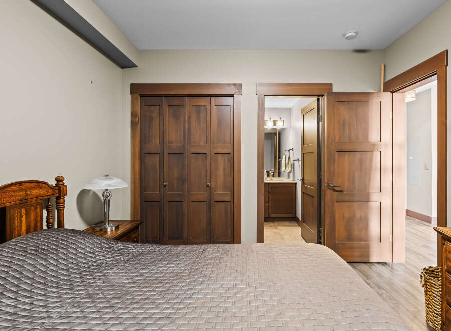 Experience comfort and style in this inviting bedroom, featuring a plush quilted bedspread and a charming wooden headboard.