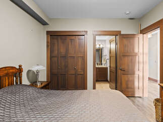 Experience comfort and style in this inviting bedroom, featuring a plush quilted bedspread and a charming wooden headboard.