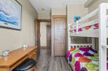 This charming bedroom features a white bunk bed with colorful bedding, perfect for accommodating guests or children.