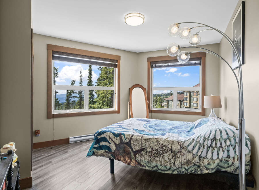 Experience breathtaking mountain views from this charming bedroom, featuring a comfortable bed adorned with a unique duvet cover.