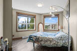 Experience breathtaking mountain views from this charming bedroom, featuring a comfortable bed adorned with a unique duvet cover.