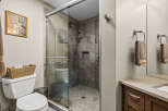 Experience modern comfort in this beautifully appointed bathroom, featuring a spacious glass-enclosed shower with sleek tilework and a convenient built-in niche.