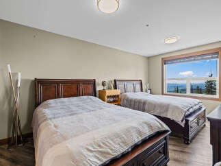 Experience breathtaking mountain views from this spacious bedroom, featuring two comfortable queen-sized beds perfect for families or groups.