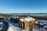 Experience luxury mountain living in this stunning ski resort property, featuring modern architecture with rustic wood accents and ample snow-covered balconies.