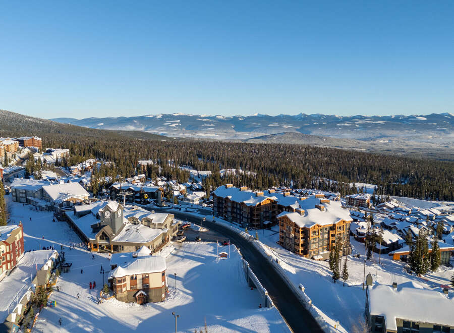 Experience the ultimate mountain lifestyle in this stunning ski resort village, featuring charming architecture and snow-covered rooftops.