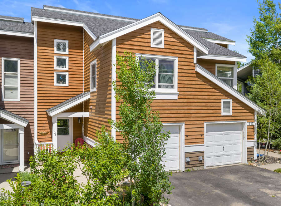 Charming townhome featuring warm wood siding and a welcoming entrance.