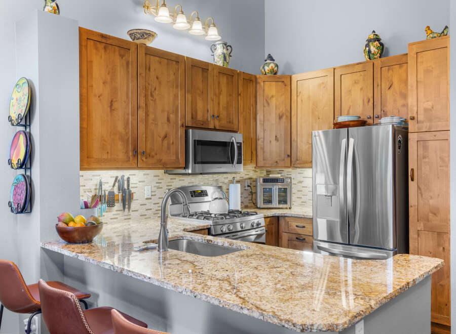 Experience culinary delight in this stunning kitchen, featuring warm wood cabinetry and a sleek granite countertop.