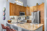 Experience culinary delight in this stunning kitchen, featuring warm wood cabinetry and a sleek granite countertop.