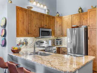 Experience culinary delight in this stunning kitchen, featuring warm wood cabinetry and a sleek granite countertop.