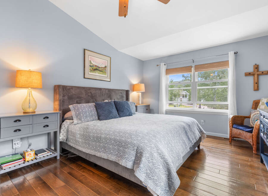 This serene bedroom features a comfortable king-size bed with a plush headboard, complemented by elegant bedside tables and lamps.
