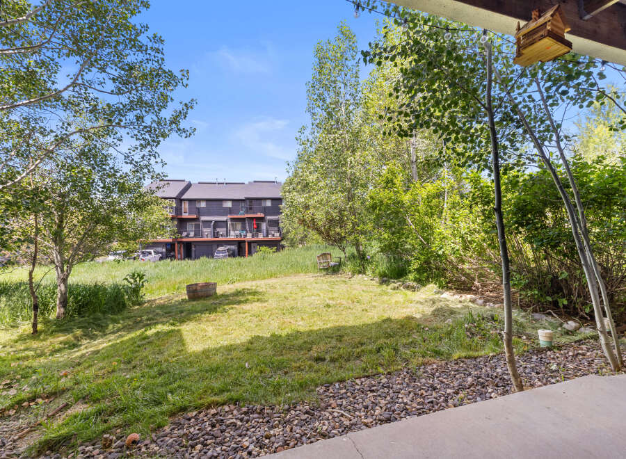 Enjoy the serene mountain setting from this property, featuring a spacious backyard with lush green grass and mature trees.
