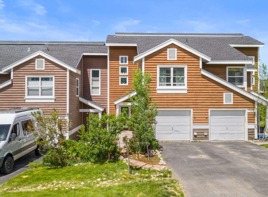 Discover this charming townhouse featuring a warm wood exterior and a welcoming entrance.