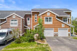Discover this charming townhouse featuring a warm wood exterior and a welcoming entrance.