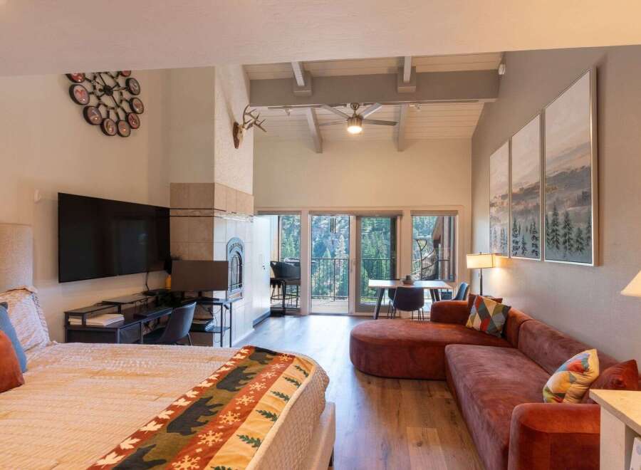 Experience mountain living in this stunning studio featuring a cozy fireplace and a large TV for entertainment.