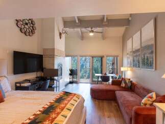 Experience mountain living in this stunning studio featuring a cozy fireplace and a large TV for entertainment.