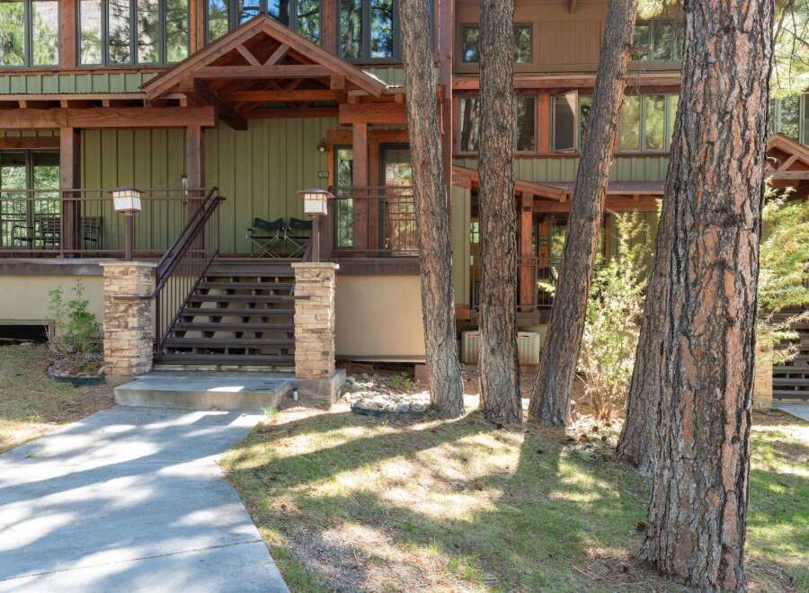 Discover this charming mountain home featuring a welcoming covered porch with comfortable seating, perfect for enjoying the serene surroundings.