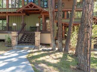Discover this charming mountain home featuring a welcoming covered porch with comfortable seating, perfect for enjoying the serene surroundings.