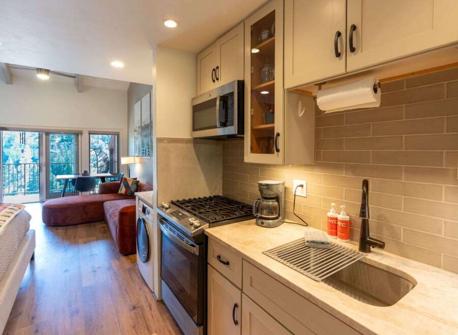 This charming studio apartment offers a compact yet functional kitchen area, complete with a microwave, gas range, and a coffee maker.