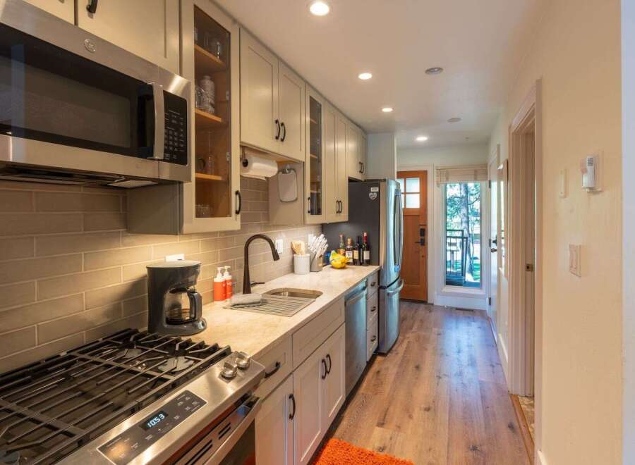 This charming kitchen features a sleek stainless steel microwave and a gas range, perfect for culinary enthusiasts.