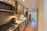 This charming kitchen features a sleek stainless steel microwave and a gas range, perfect for culinary enthusiasts.