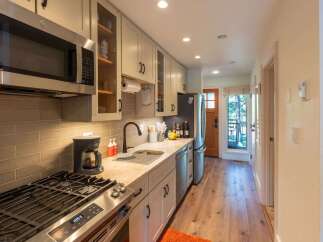 This charming kitchen features a sleek stainless steel microwave and a gas range, perfect for culinary enthusiasts.