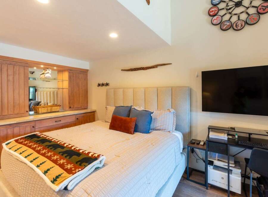 Experience ultimate comfort in this beautifully appointed bedroom, featuring a plush king-sized bed adorned with a cozy bear-themed blanket.