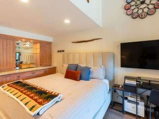 Experience ultimate comfort in this beautifully appointed bedroom, featuring a plush king-sized bed adorned with a cozy bear-themed blanket.
