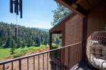 Enjoy breathtaking panoramic views from this stunning property, featuring a spacious balcony overlooking a lush green golf course nestled within a dense pine forest.