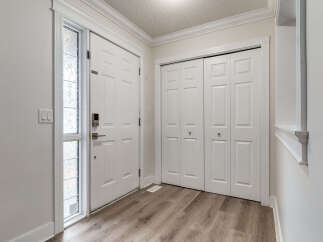 Step into this inviting entryway featuring a modern front door with a sleek digital lock and a decorative glass sidelight.