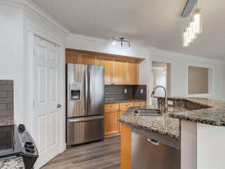 This modern kitchen boasts stainless steel appliances, including a French door refrigerator and a built-in dishwasher.
