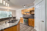 This spacious kitchen boasts granite countertops and a double sink, perfect for meal preparation.