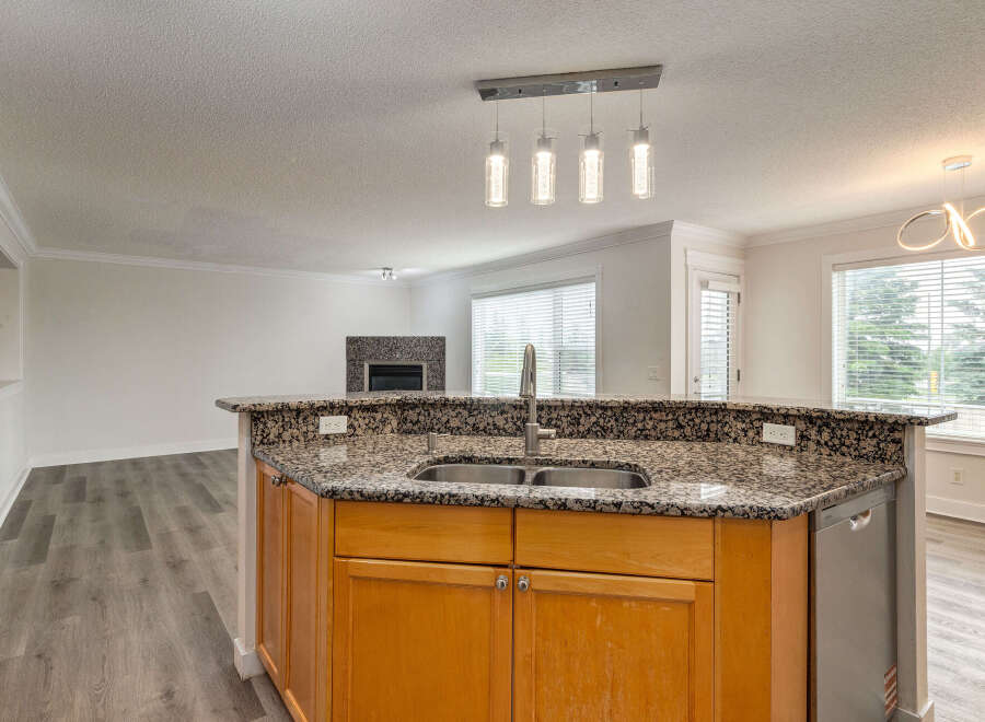 Experience modern living in this beautifully updated kitchen, featuring a granite-topped island with a double sink and ample cabinet space.