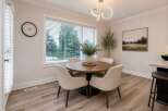 This dining area features a round wooden table with four upholstered chairs, perfect for intimate gatherings.